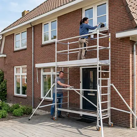 Steiger in gebruik voor buitenschilderwerk aan een woning